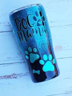 a blue glitter tumbler with paw prints on the side that says doc and mama