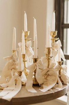 a table topped with lots of white candles and napkins on top of each other