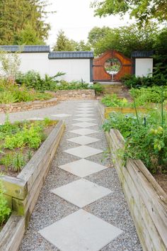 an outdoor garden area with various plants and wooden fenced in walkways that lead to the front door