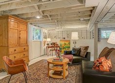 a living room filled with furniture and lots of wooden cabinets on top of a rug