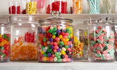 many different colored candies in glass jars