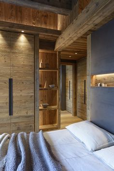 a bed in a room with wooden walls and shelves on either side of the bed