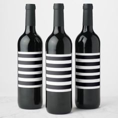 three wine bottles with black and white stripes on them