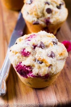 two muffins sitting on top of a wooden cutting board