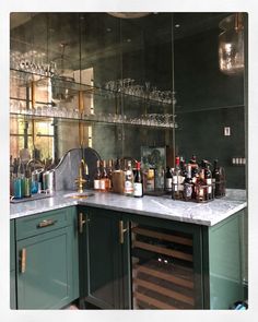 a bar with many bottles and glasses on top of it in front of a mirror