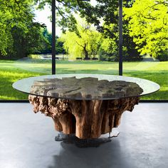 a table made out of wood and glass in front of a window with trees outside