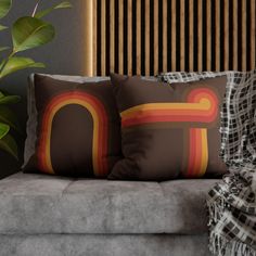 two pillows sitting on top of a couch next to a potted plant