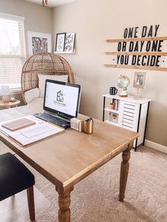 a laptop computer sitting on top of a wooden table in front of a wall mounted sign