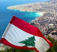 an italian flag flying in the wind over a city and water with buildings on both sides