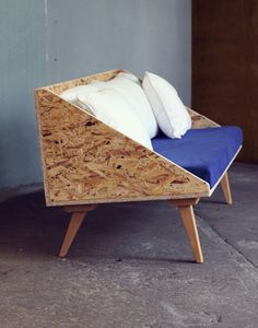 a chair made out of plywood with two pillows on it