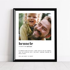 a black framed poster with an image of a man holding a child in his arms