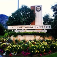 there is a sign that says birmingham young university in front of some flowers and trees