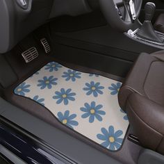 the interior of a car with a blue and yellow flowered floor mat on it