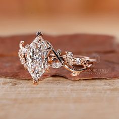 a close up of a diamond ring on top of a leaf