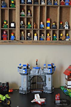 there are many legos on the table and in front of it is a shelf