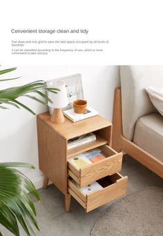 a small wooden table with two drawers on it and a plant in the corner next to it