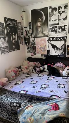 an unmade bed in a bedroom with posters on the wall and pictures above it