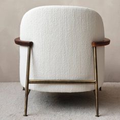 a white chair sitting on top of a carpeted floor next to a wooden frame