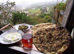 a pizza and some drinks on a window sill