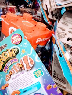 an orange and blue carton of soda next to some other packaged items in a store