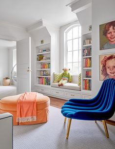 a living room filled with furniture and bookshelves next to a window covered in pictures