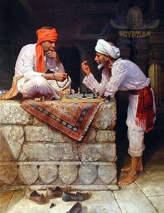 two men playing chess in front of a stone wall, with shoes on the ground