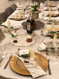 the table is set with plates, silverware and place settings for an elegant dinner