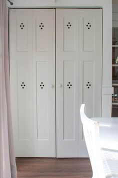 a room with white closets and wooden flooring, along with a dining table