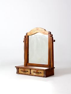 an old wooden vanity with mirror and drawers on it's sides, against a white background