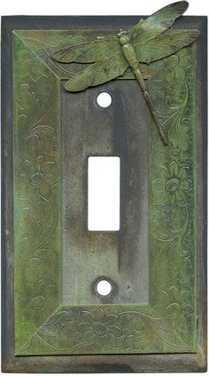 a metal switch plate with a dragonfly on it