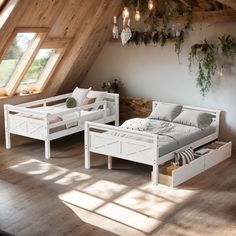 two beds in a room with wooden flooring and white walls, one has drawers under the bed