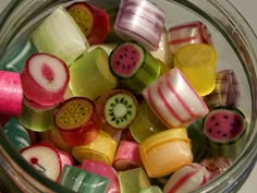 a glass jar filled with cut up fruit and veggies in pastel colors