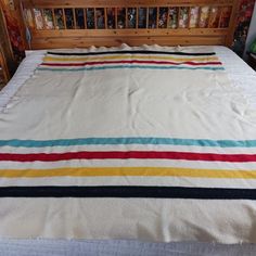 the bed is made with multicolored blankets