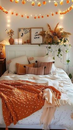 a white bed topped with lots of pillows and blankets next to a night stand filled with lights