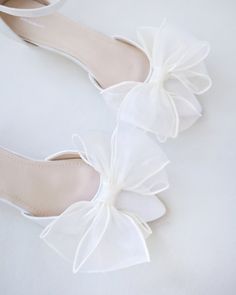 white wedding shoes with bows on them