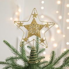 a gold star ornament hanging from a christmas tree