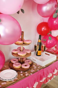 a table topped with donuts and pink balloons