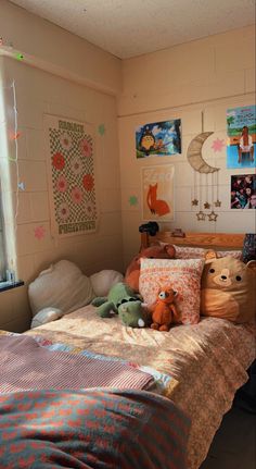 there is a small child's bedroom with toys on the bed and pictures on the wall