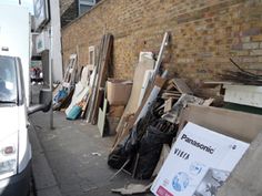 a white truck parked next to a building with lots of junk on the side of it