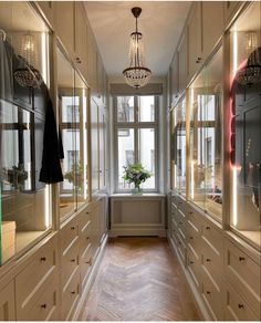 a long hallway with lots of cabinets and a chandelier hanging from the ceiling