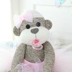 a teddy bear wearing a pink tutu with a pacifier in it's mouth