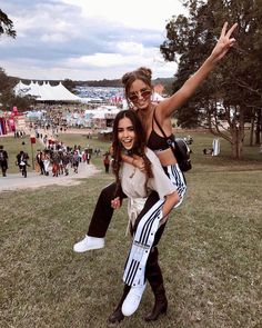 two women are posing for the camera in front of an audience at a music festival