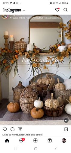 a fireplace with pumpkins and gourds in baskets on top of the mantle