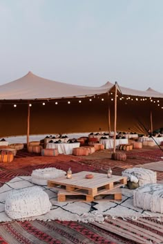 a large tent set up with tables and chairs in front of it on top of a rug