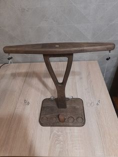 an ironing board sitting on top of a wooden table next to a bottle opener