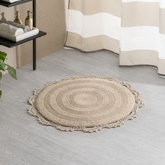 a round rug on the floor next to a shelf with towels and toiletries in it