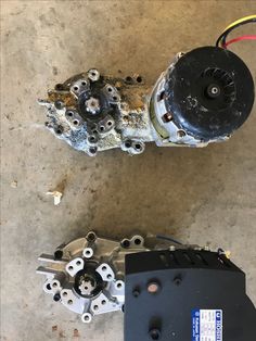 two motor parts sitting on the ground next to each other