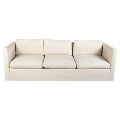 a white couch sitting on top of a white floor