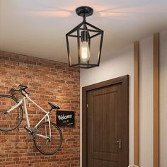 a bicycle mounted to the side of a brick wall next to a door with a light on it