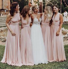 the bridesmaids are all dressed in pink dresses and one is wearing a white dress